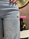 Jeans con strappi e borchiette