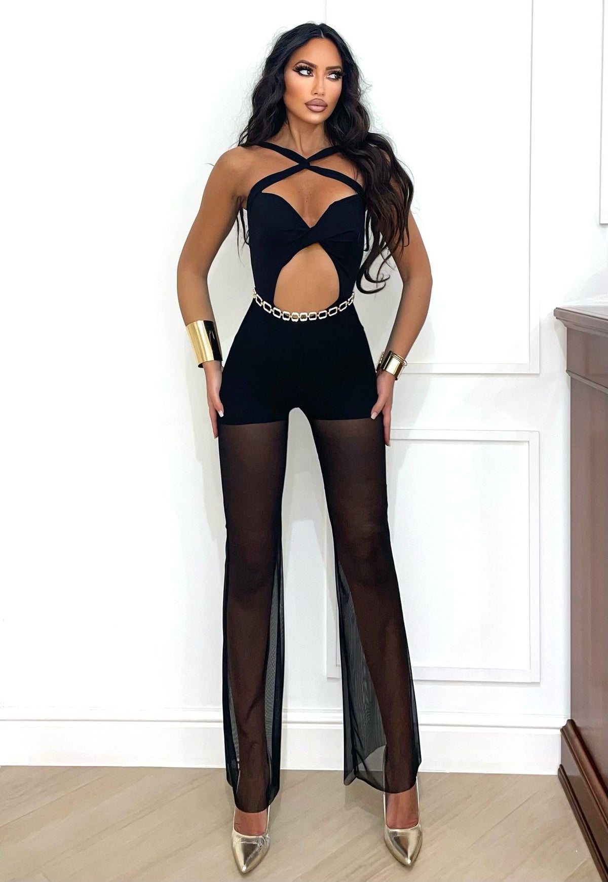 Tuta nera con incroci e pantalone con trasparenze