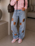 Jeans con aperture e fiocco in strass