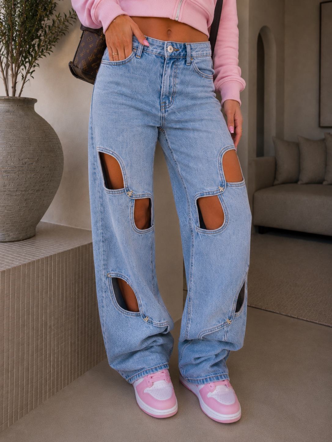 Jeans con aperture e fiocco in strass