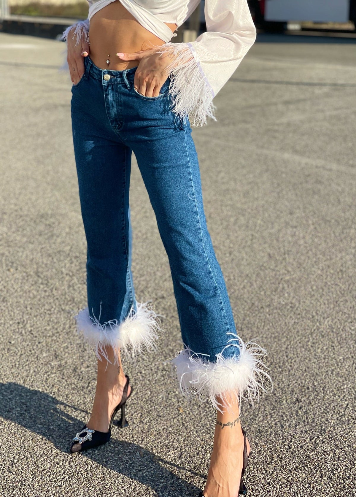 Jeans con piume bianche