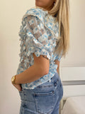 Camicia celeste a manica corta con fiori
