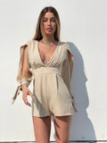 Tutina beige con fiocchetti