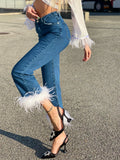 Jeans con piume bianche