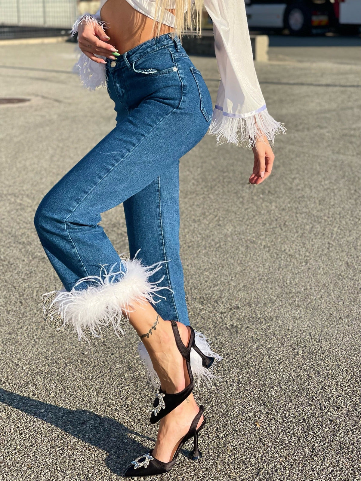 Jeans con piume bianche