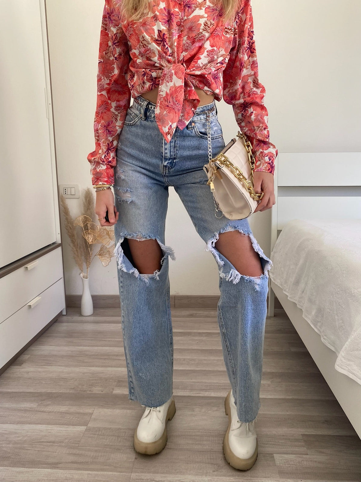 Jeans con strappi e cintura con catene