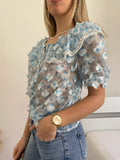 Camicia celeste a manica corta con fiori