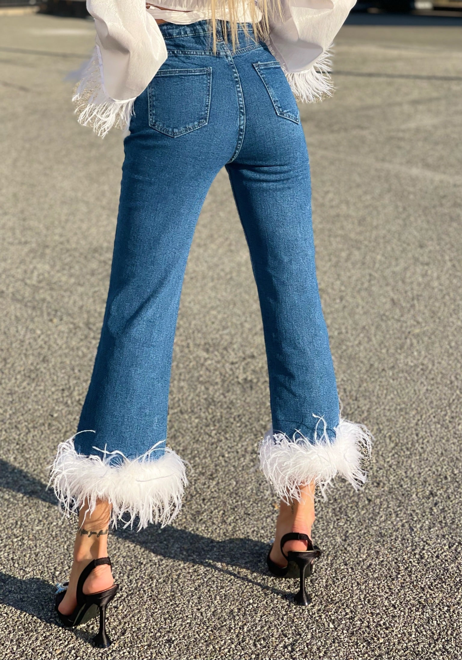 Jeans con piume bianche