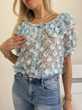 Camicia celeste a manica corta con fiori