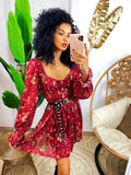 Abito bordeaux scollato con fiori rossi