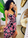 Abito con gonna asimmetrica e fiori rosa in base nero