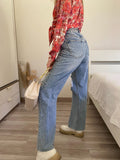 Jeans con strappi e cintura con catene