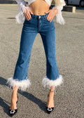 Jeans con piume bianche