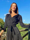 Abito nero con maniche con piume