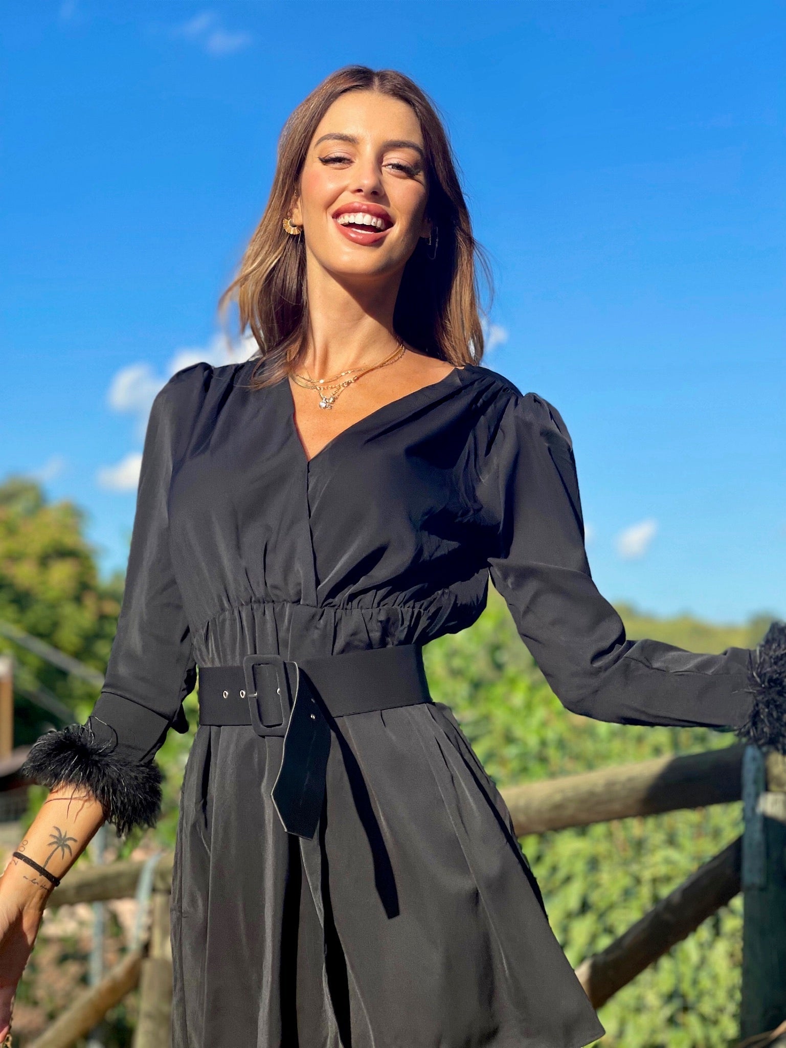 Abito nero con maniche con piume
