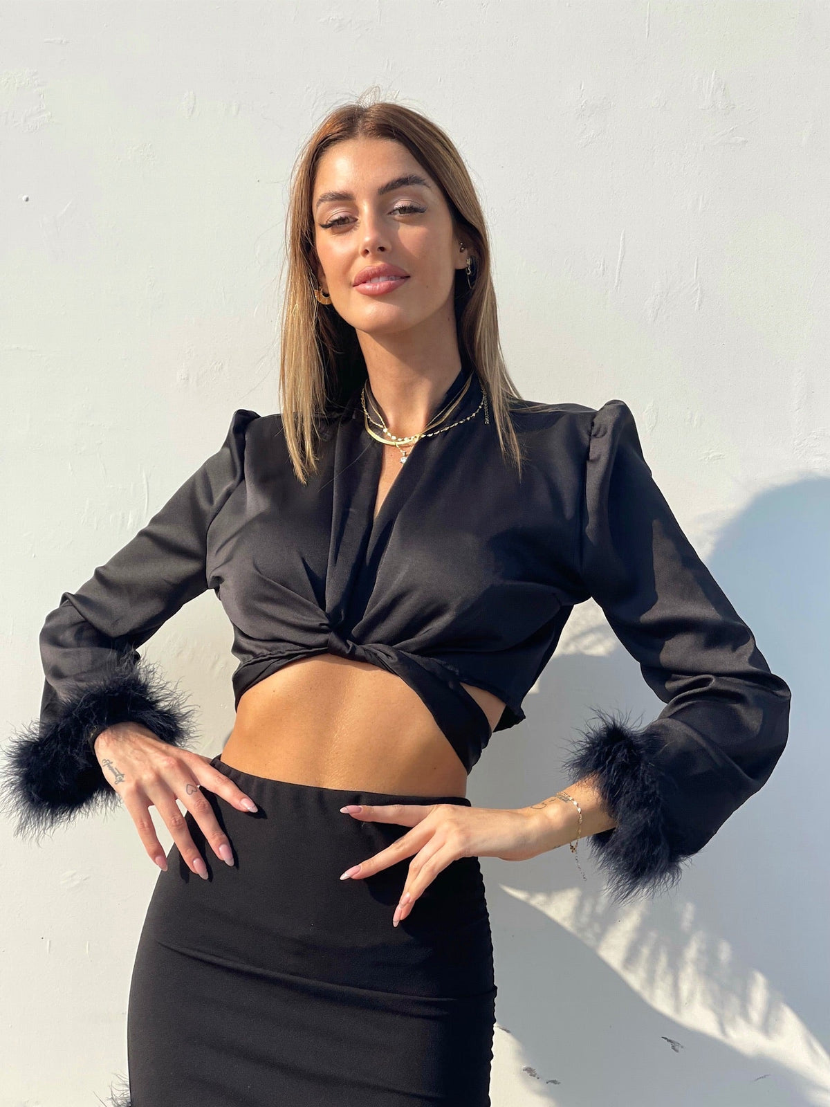 Top nero con piume
