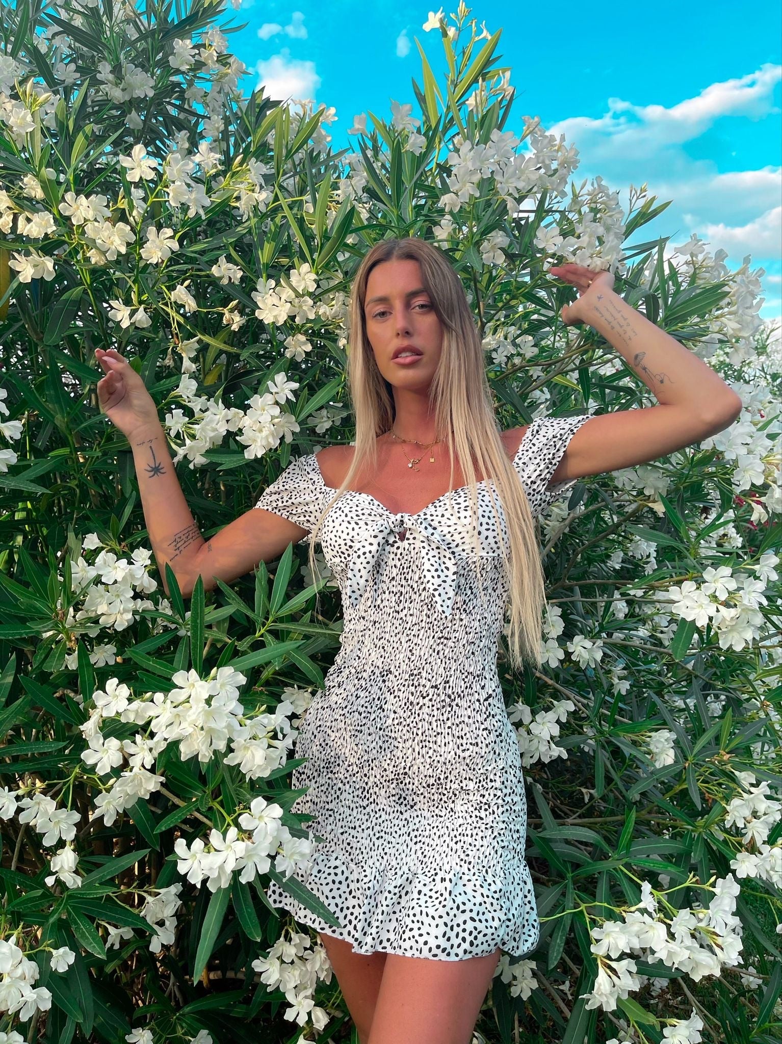 Abito a pois aderente con fiocco bianco